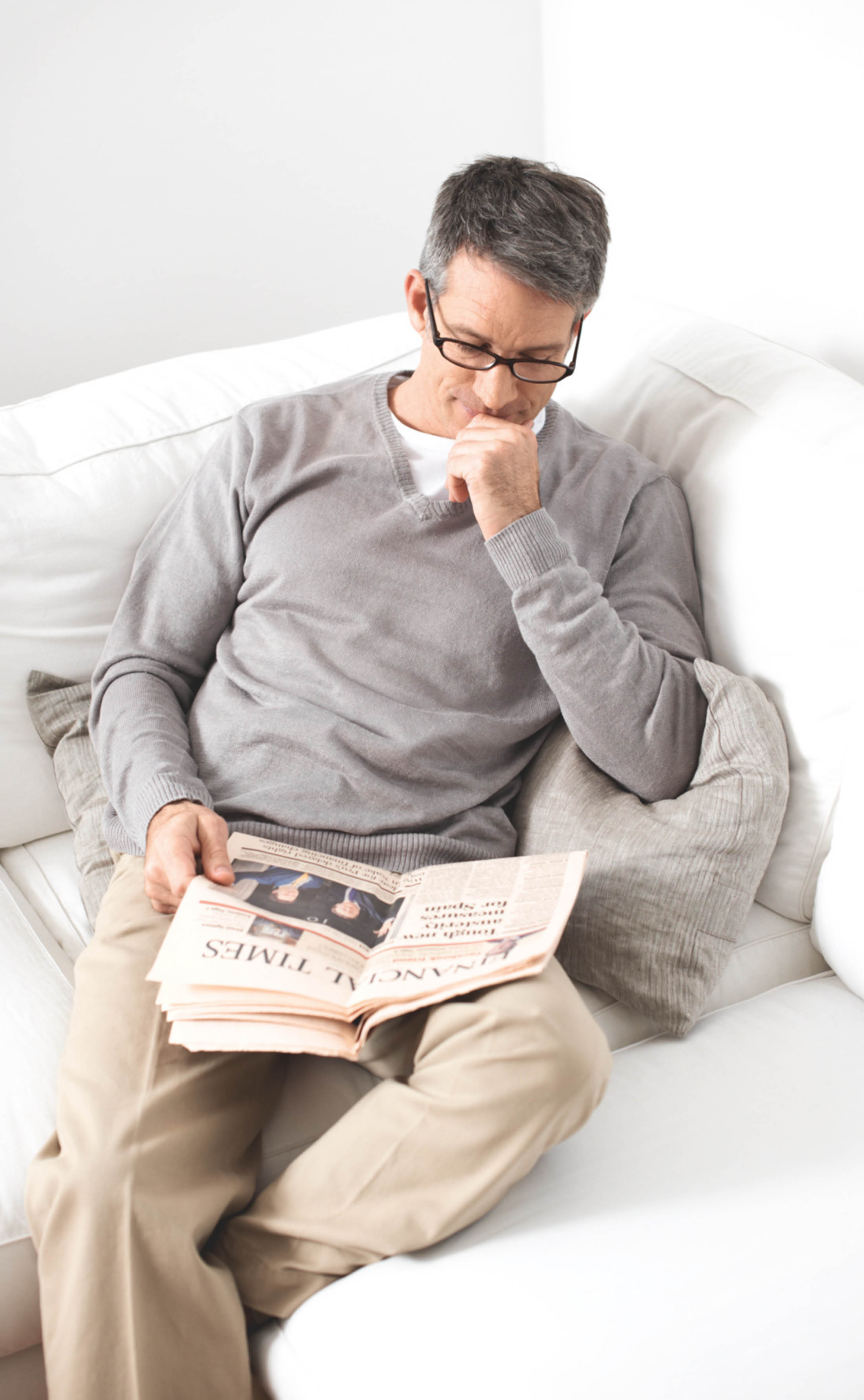 Uomo che legge il giornale sul divano